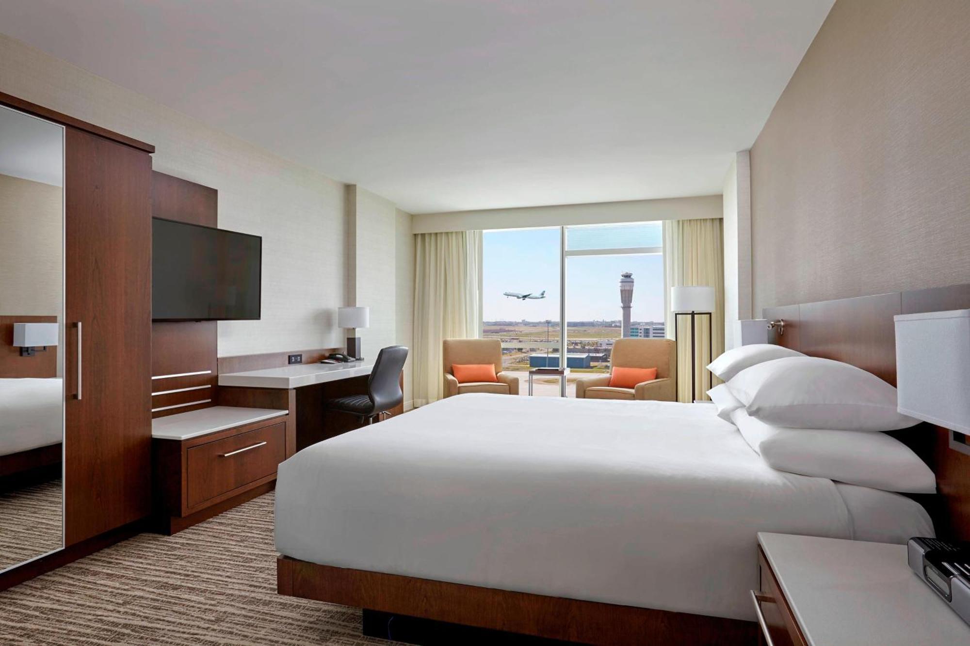 Quarto com Cama King-size e Vista do Aeroporto